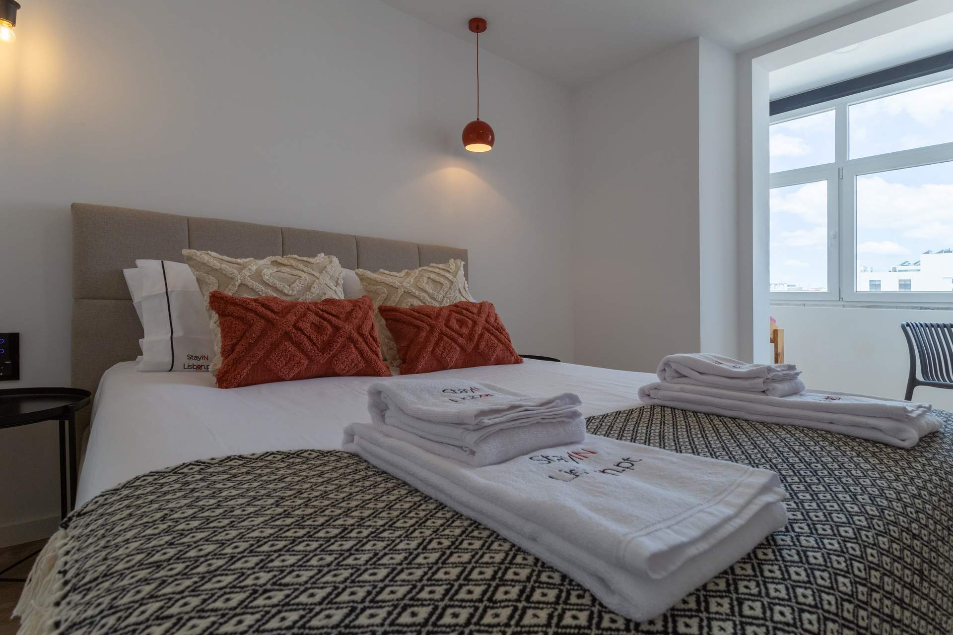 Made-up bedroom with fresh towels in a Lisbon apartment managed by LD Ninja Stays